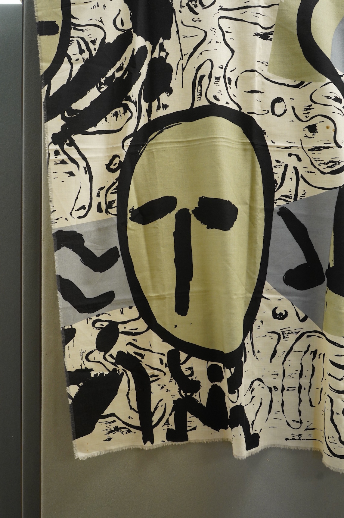 A large wool scarf designed with large faces by Brian Bolger, (RCA 1983) and The Cloth.100cm wide x 140cm. Condition - good